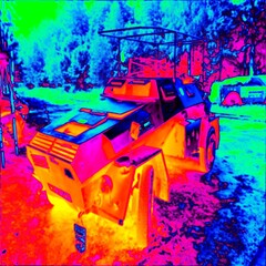 Small tractor in the countryside. Thermal photography