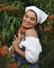 Beautiful happy young girl with peach garden in summer