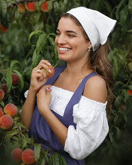 Beautiful happy young girl with peach garden in summer