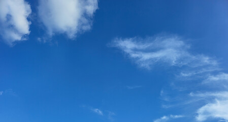 Blue sky with white clouds, natural background for weather, travel, environment, and inspirational themes. Bright clear sky with cloudscape. No limit concept. Blue sky with fluffy cumulus clouds.