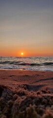 Obraz premium sunset over the sea with gentle waves and warm sky