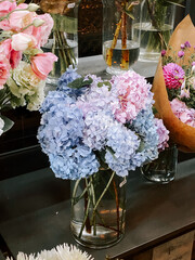 Beautiful floral arrangement featuring blue and pink hydrangeas in a glass vase