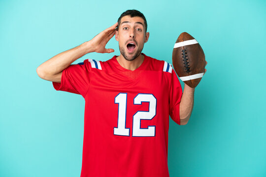 Young caucasian man playing rugby isolated on blue background with surprise expression