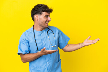 Young surgeon doctor man isolated on yellow background with surprise facial expression