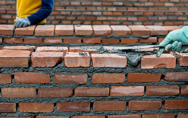 Close up of bricklayers building walls