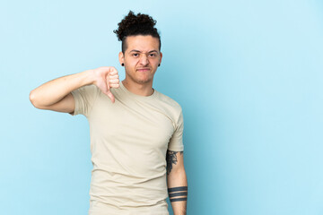 Caucasian man over isolated background showing thumb down with negative expression