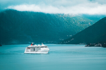 Modern cruise ship by mountains in Montenegro
