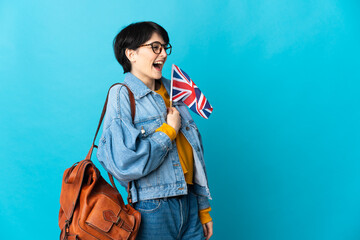 Woman holding an United Kingdom flag over isolated background laughing in lateral position