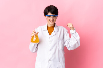 Young scientific woman isolated on pink background doing strong gesture