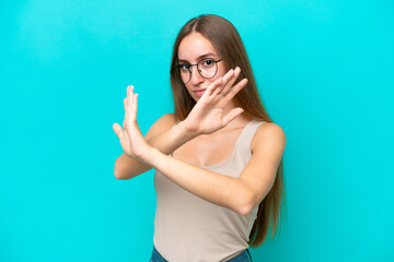 Fototapeta premium Young caucasian woman isolated on blue background nervous stretching hands to the front