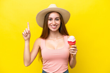 Young caucasian with a cornet ice cream isolated on yellow background pointing up a great idea