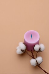 Pink Candle with Cotton Branch on Beige Background