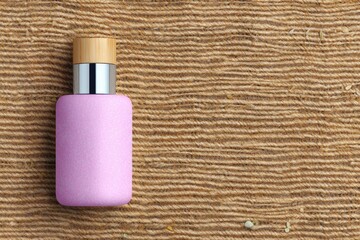 Pink Bottle with Bamboo Cap on Jute Background