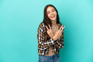 Young French woman isolated on blue background smiling and showing victory sign