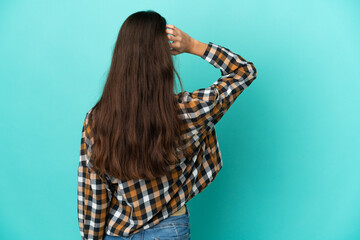 Young French woman isolated on blue background in back position and thinking