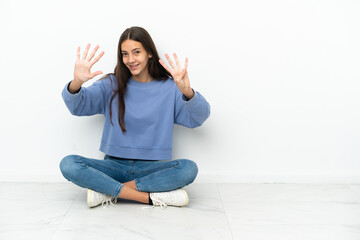 Young French girl sitting on the floor counting nine with fingers