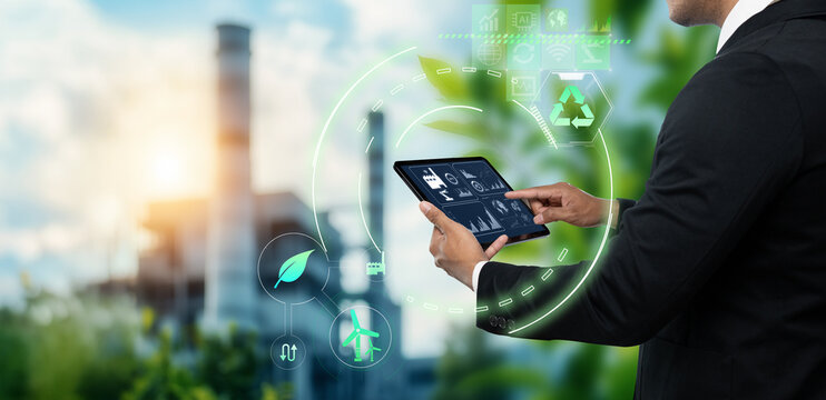 Sustainable Technology for Industry Smart Solutions for Environmental Management concept, business man using digital tablet on blurred green industry as background