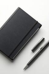 Black notebook with pen, and white desk.