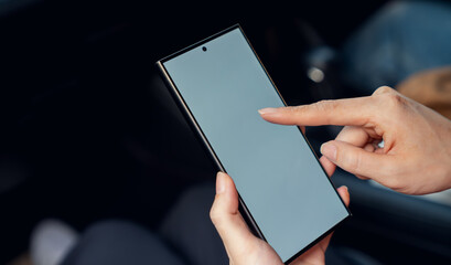 Woman sitting in a private car and hand holding smartphone mockup of blank screen, Take your screen to put on advertising