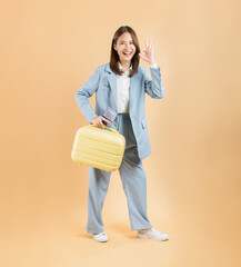 Asian businesswoman holding a suitcase and shows ok sign, The concept vacation after hard work.