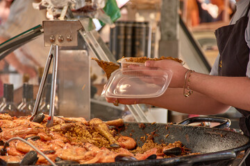 Shopping at the Aix, Provence market, with a vendor serving prepared food to a customer