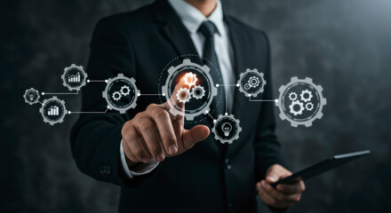 Man in Dark Suit Interacting with Digital Gear Interface Holding Tablet Representing Business Automation and Technological Innovation on Dark Gray Background