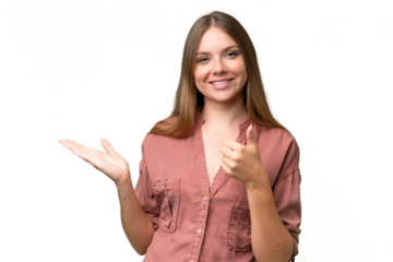 Young beautiful blonde woman over isolated background holding copyspace imaginary on the palm to insert an ad and with thumbs up