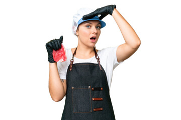 Butcher woman wearing an apron and serving fresh cut meat over isolated chroma key background doing...