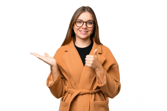 Young blonde woman over isolated chroma key background holding copyspace imaginary on the palm to insert an ad and with thumbs up