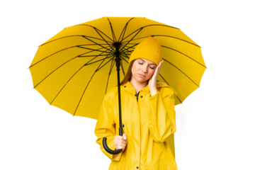 Young blonde woman with rainproof coat and umbrella over isolated chroma key background with headache