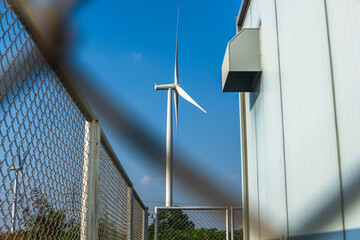 Main alternative electric power building generating from wind turbine against blue sky background