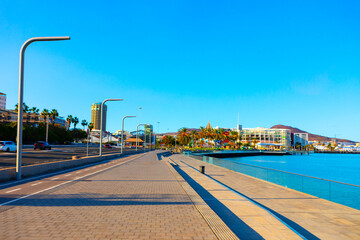 Modern seaside promenade in Las Palmas, Gran Canaria, bathed in sunlight with clear blue skies and...