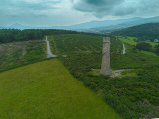 A sweeping aerial shot capturing the historic Ballycorus Lead Mines Chimney surrounded by lush...