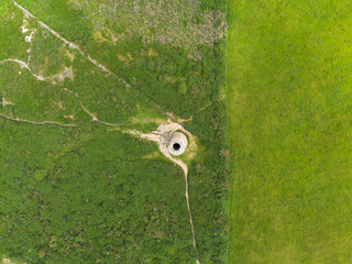 A very wide, top-down aerial view revealing the Ballycorus Lead Mines Chimney and a network of...