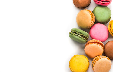 Macarons, macaroons, colorful assortment border design, vibrant pink, yellow, green, brown French pastries creamy fillings, macaroon isolated on white background, flat lay, top view, gourmet dessert