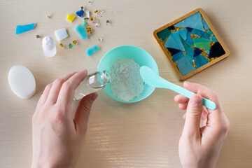 Adding gypsum powder to water for mixing casting compound to make handmade mosaic coaster with...