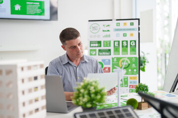 Adult Caucasian man reviewing ESG report for sustainable green business strategy promoting net zero carbon emissions and environmental responsibility