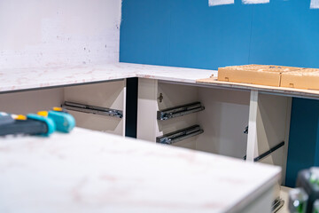 Vue d’ensemble d’une cuisine en plein montage, avec des éléments de mobilier partiellement...
