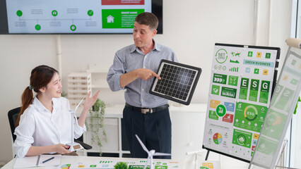 Business professionals discuss ESG green business strategies and renewable energy solutions for...