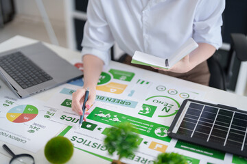 Asian adult woman analyzing green business strategy documents for sustainable logistics and carbon footprint reduction ESG goals
