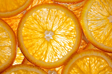 The photograph shows the surface details of a halved orange, studio light from behind.