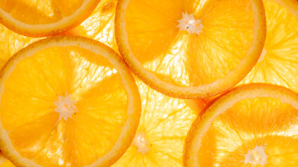 The photograph shows the surface details of a halved orange, studio light from behind.