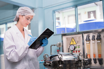 Drinking water production plant. Female worker inspecting of water pump system, pipes station, Water pressure system, tank, drinking water filling machine