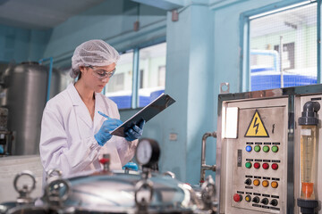 Drinking water production plant. Female worker inspecting of water pump system, pipes station, Water pressure system, tank, drinking water filling machine