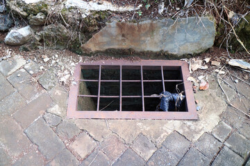 Metal Grate Covering Open Drain in Stone Pathway