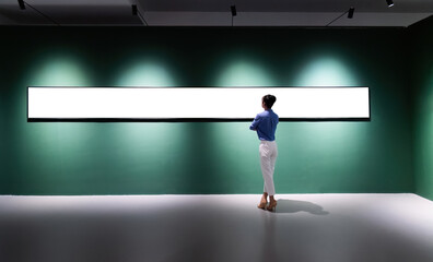 Woman standing and looking long blank picture