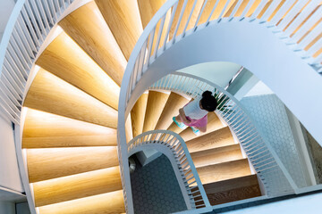 Woman walking on spiral staircase