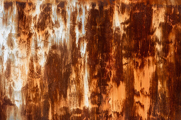 Close-up of a weathered, rusty metal surface with textured streaks of brown, orange, and white...