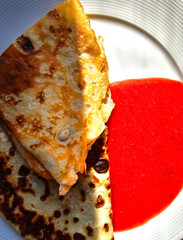 pancakes with red jam on a plate, close-up