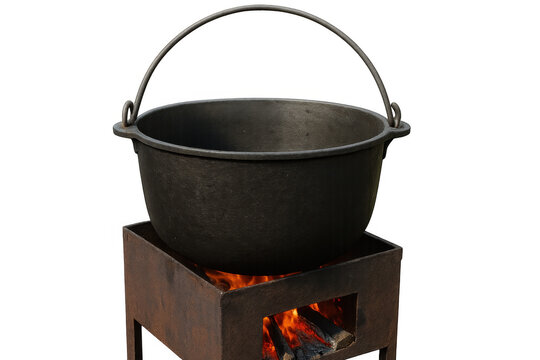 Black cast iron cauldron hanging over burning wood fire on a transparent background, perfect for cooking traditional dishes